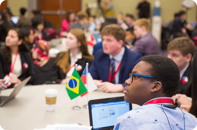 Students sitting at a roundtable event hosted by Knovva Academy listen to a presentation.